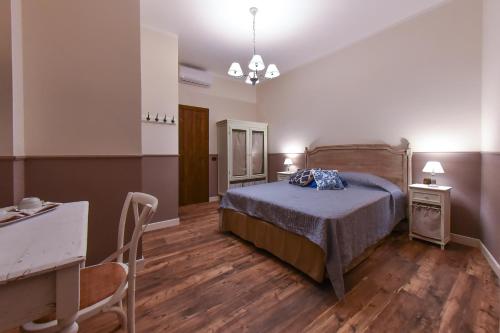 1 dormitorio con 1 cama, mesa y sillas en Parco dei Templi en Agrigento