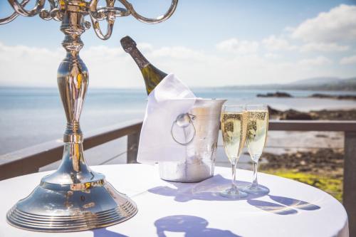 a table with a bottle of champagne and a glass at Redcastle Hotel in Moville