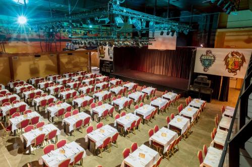 an empty banquet hall with red and white tables and chairs at Magic Robin Hood in Albir
