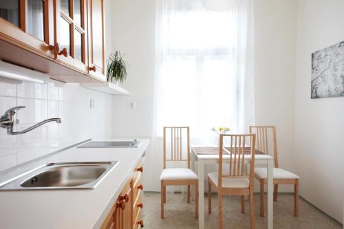 a kitchen with a sink and a table with chairs at Angel City Aparthotel in Prague