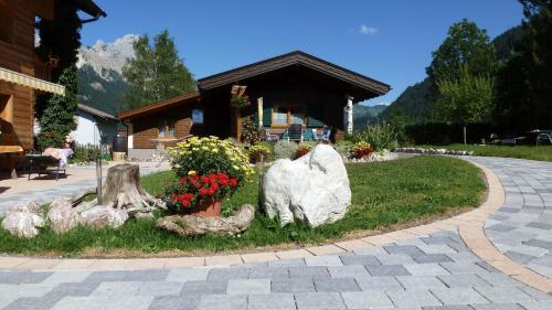a garden with rocks and flowers in front of a building at Almdorf Tirol in Haldensee