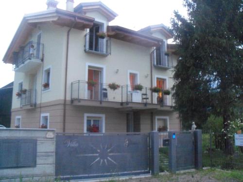 a large white house with balconies and a fence at Villa Gioiosa in Piantedo