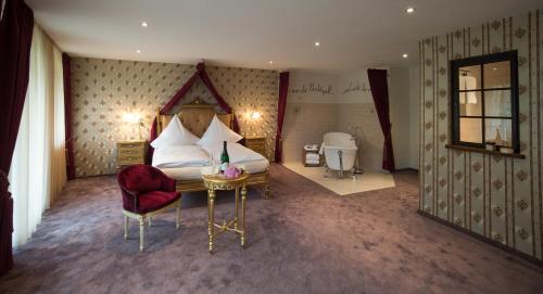 a bedroom with a bed and a chair and a table at Hotel Lellmann in Löf