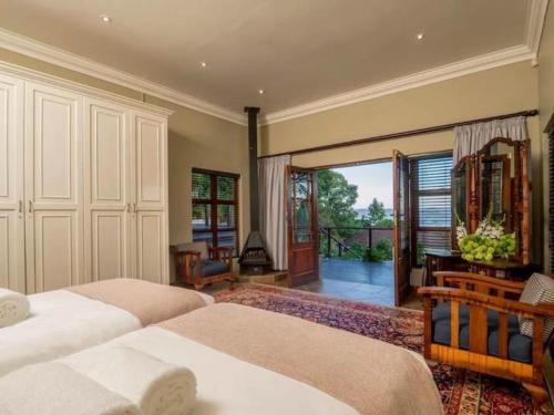 a bedroom with two beds and a balcony at 11 Protea in Knysna