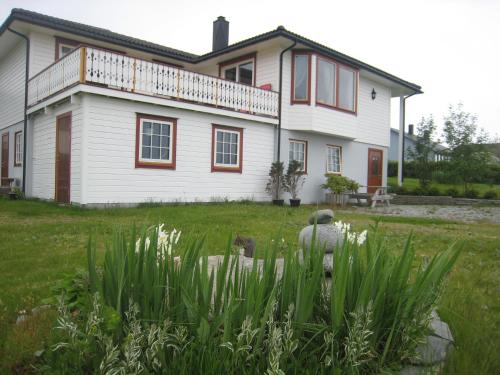 a large white house with a balcony on top of it at Milas House two apartments in Fredvang