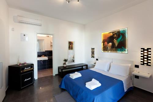 1 Schlafzimmer mit einem blauen Bett und einem Badezimmer in der Unterkunft Bed & Blues in Torre Lapillo