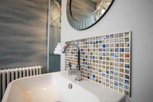 ein Bad mit einem Waschbecken und einem Spiegel in der Unterkunft Brighton House in Brighton & Hove