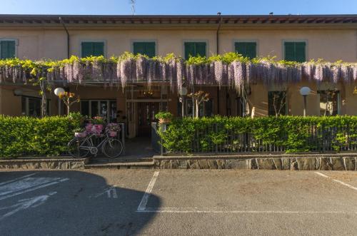 a building with lots of purple wisterias at Hotel Ristorante Bologna in San Piero in Bagno