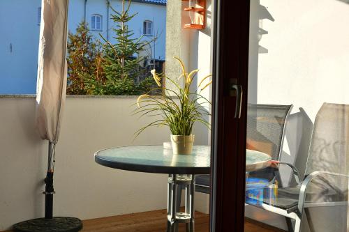 ナウムブルクにあるFerienwohnung Domschatzのバルコニーに鉢植えのテーブル