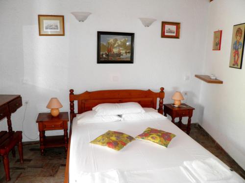a bedroom with a white bed with two tables and two lamps at Akis Apartments Kontogialos-Pelekas in Pelekas