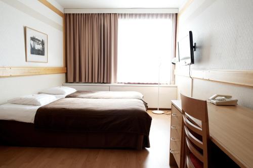 a hotel room with a bed and a window at Hotel Korpilampi in Espoo