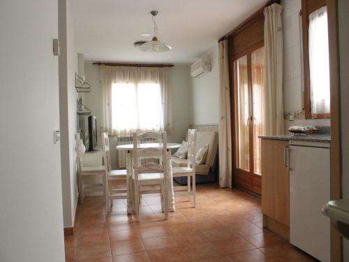 
a kitchen with a table, chairs and a refrigerator at Hotel Apartamentos Domenc in Aren
