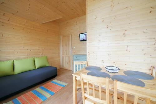 a living room with a couch and a table at Domki Letniskowe Paula in Darłowo