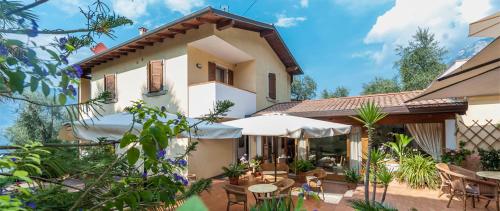 a house with a patio with tables and umbrellas at B&B Casa Benamati by Kelly in Malcesine