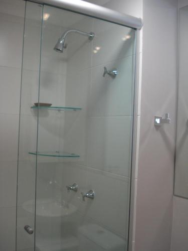 cabina de ducha de cristal con puerta de cristal en Apartamento Menino Deus, en Porto Alegre