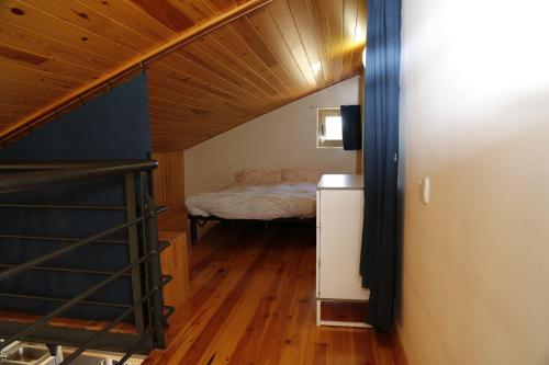 Habitación pequeña con cama y escalera en Casa Trillo Apartamentos, en Torres del Obispo