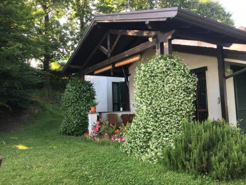 a house with a large bush in front of it at Elleboro in Carugo