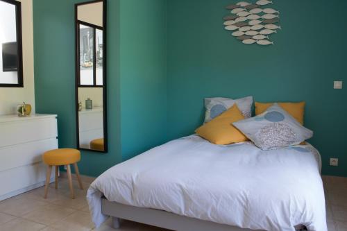 - une chambre bleue avec un lit et un miroir dans l'établissement Le loft du Clos d'Esquay, à Esquay-sur-Seulles