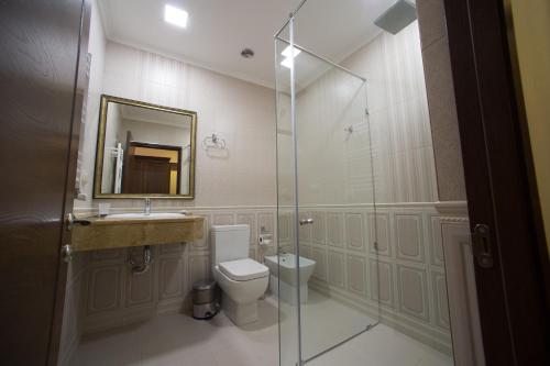 y baño con aseo, lavabo y ducha. en Boulevard Hotel en Ereván