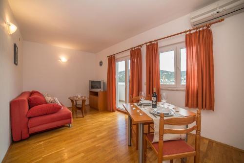 - un salon avec une table et une chaise rouge dans l'établissement Villa Albatros, à Vinišće