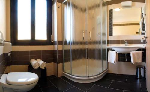 a bathroom with a shower and a toilet and a sink at Hotel Anna in Malcesine