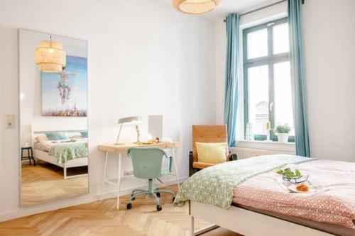 een slaapkamer met een bed, een bureau en een spiegel bij Enjoy Leipzig in Leipzig