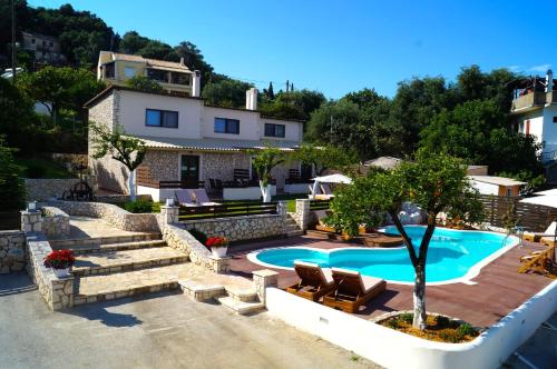 a villa with a swimming pool and a house at Anita Village in Perama