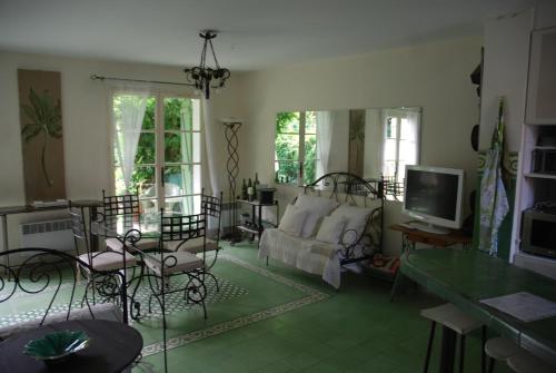 un salon avec un canapé et une télévision dans l'établissement L'ombre de la Glycine du Golfe de Saint Tropez, à Gassin