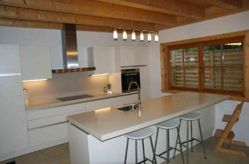 a kitchen with a sink and a counter with bar stools at Ado's Haus in Niederau