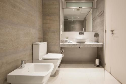 La salle de bains est pourvue de toilettes blanches et d'un lavabo. dans l'établissement Palo Santo Hotel, à Buenos Aires