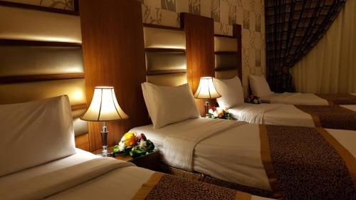 a hotel room with two beds and two lamps at Province Al Sham Hotel in Al Madinah