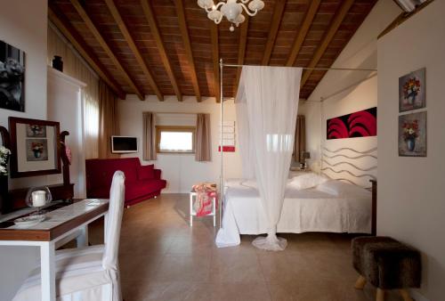 um quarto com uma cama e um sofá vermelho em Massoni Bed and Breakfast em Peschiera del Garda