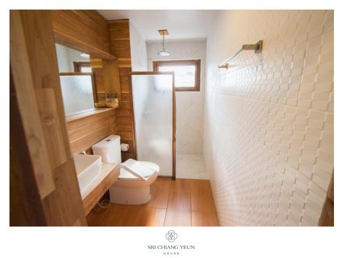 a bathroom with a white toilet and a shower at Sri Chiang Yeun House in Chiang Mai