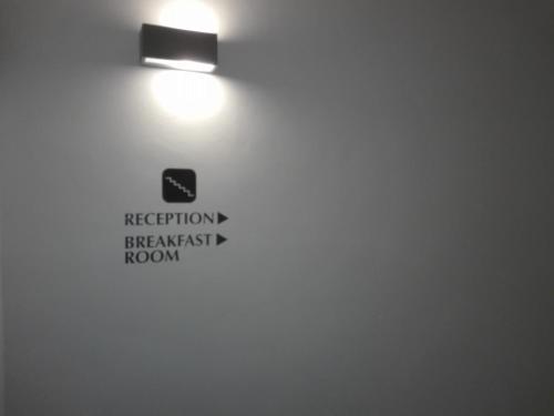 a light on a wall with a sign on it at Hotel Bocciolo in Orta San Giulio