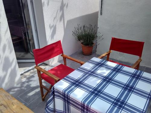 two red chairs and a table on a porch at Apartman Nora in Hvar