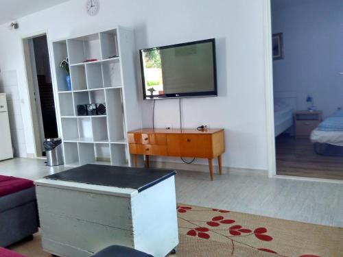 a living room with a tv on a wall at Apartman Nora in Hvar