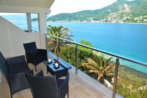 a balcony with chairs and a table and the ocean at Apartments MaXhit in Tivat