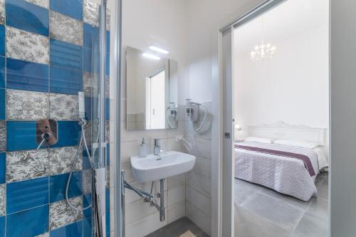a bathroom with a shower and a sink and a bed at Incentro in Gallipoli