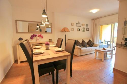a dining room and living room with a table and chairs at Apartment Albir Playa Florida in Albir