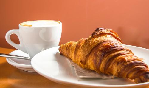 a croissant on a plate next to a cup of coffee at Victor Hotel in Villa Carlos Paz