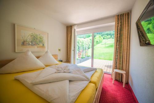 ein Hotelzimmer mit einem Bett und einem großen Fenster in der Unterkunft Chalet Bernegg in Sautens
