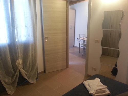 a bedroom with a shower curtain and a table at Appartamento Vincenzina in Lampedusa
