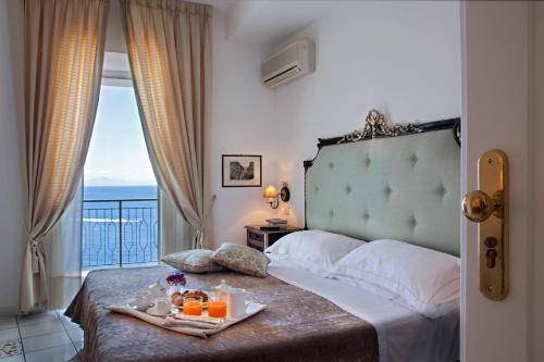 a hotel room with a bed with a tray of oranges at Hotel Onda Verde in Praiano