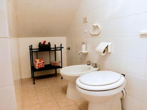 ein weißes Bad mit einem WC und einem Waschbecken in der Unterkunft Centralissimo nel cuore del borgo in Suvereto