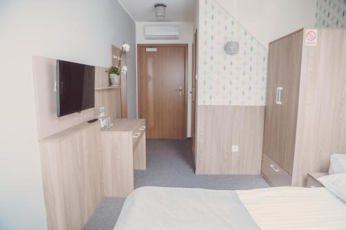 a hotel room with a bed and a television at Hotel Duet in Człuchów