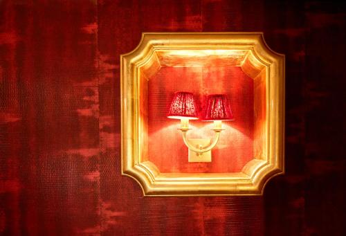 a gold picture frame with a lamp on a wall at Maison Au Cheval Noir in Maastricht