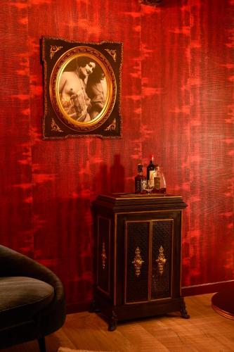 a red wall with a picture and a table in a room at Maison Au Cheval Noir in Maastricht