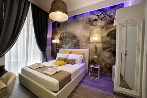 ナポリにあるBourbon Houseのベッドルーム1室(ベッド1台付)、壁画が備わります。