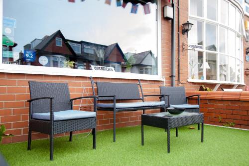 three chairs and a table on a patio at The Penrhyn in Blackpool