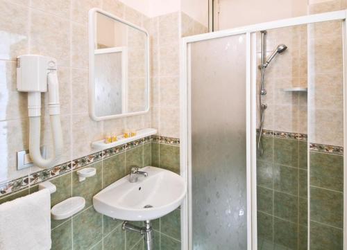 uma casa de banho com um lavatório e um chuveiro em Hotel Ferrara em Cattolica